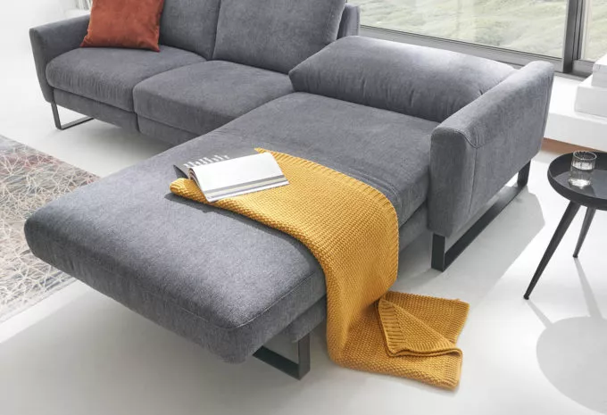 graue Couch in L-Form mit Liegefläche