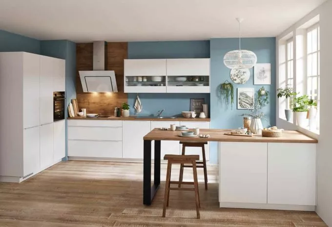 klassische weiße Küche mit Arbeitsplatte aus Holz und hellblauer Wandfarbe